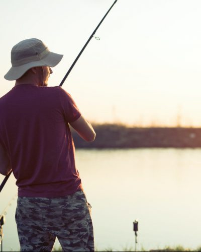 Men fishing in sunset and relaxing while enjoying hobby