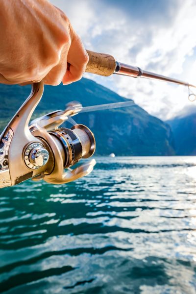 Woman fishing on Fishing rod spinning in Norway.